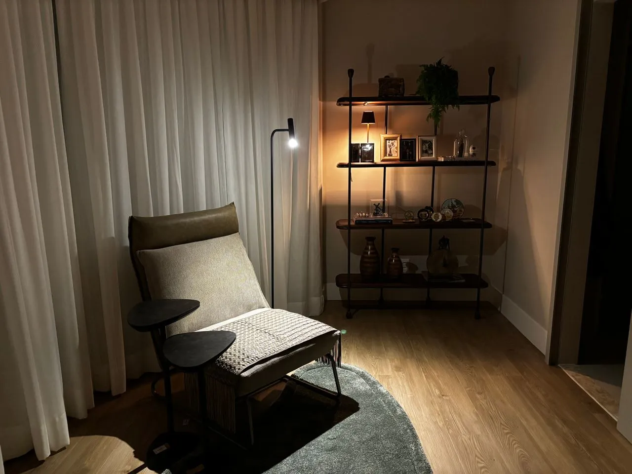 Reading chair beside illuminated display shelving