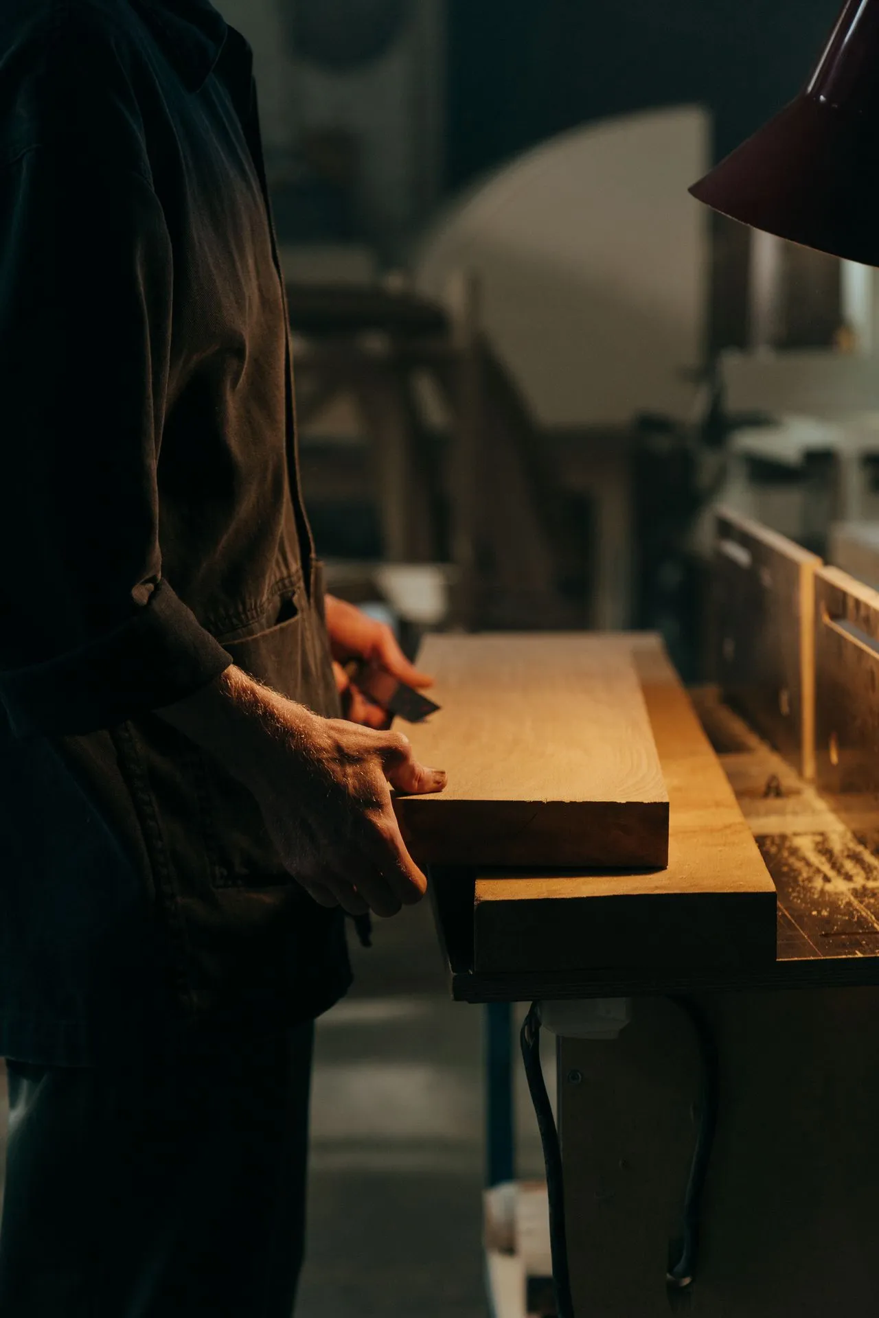 Craftsperson working timber in low light