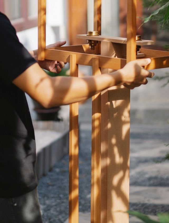 Hands working with a warm timber structure