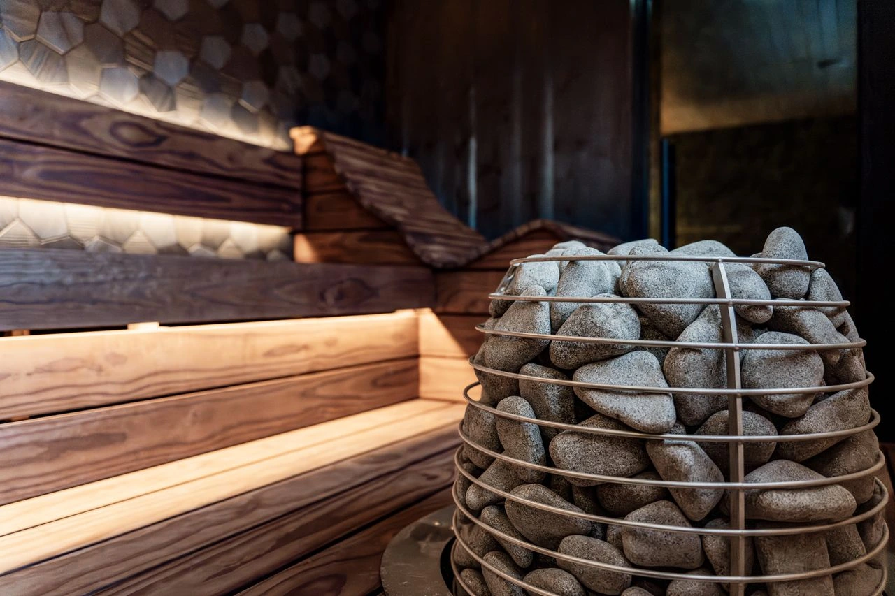 Stone sauna heater against layered timber