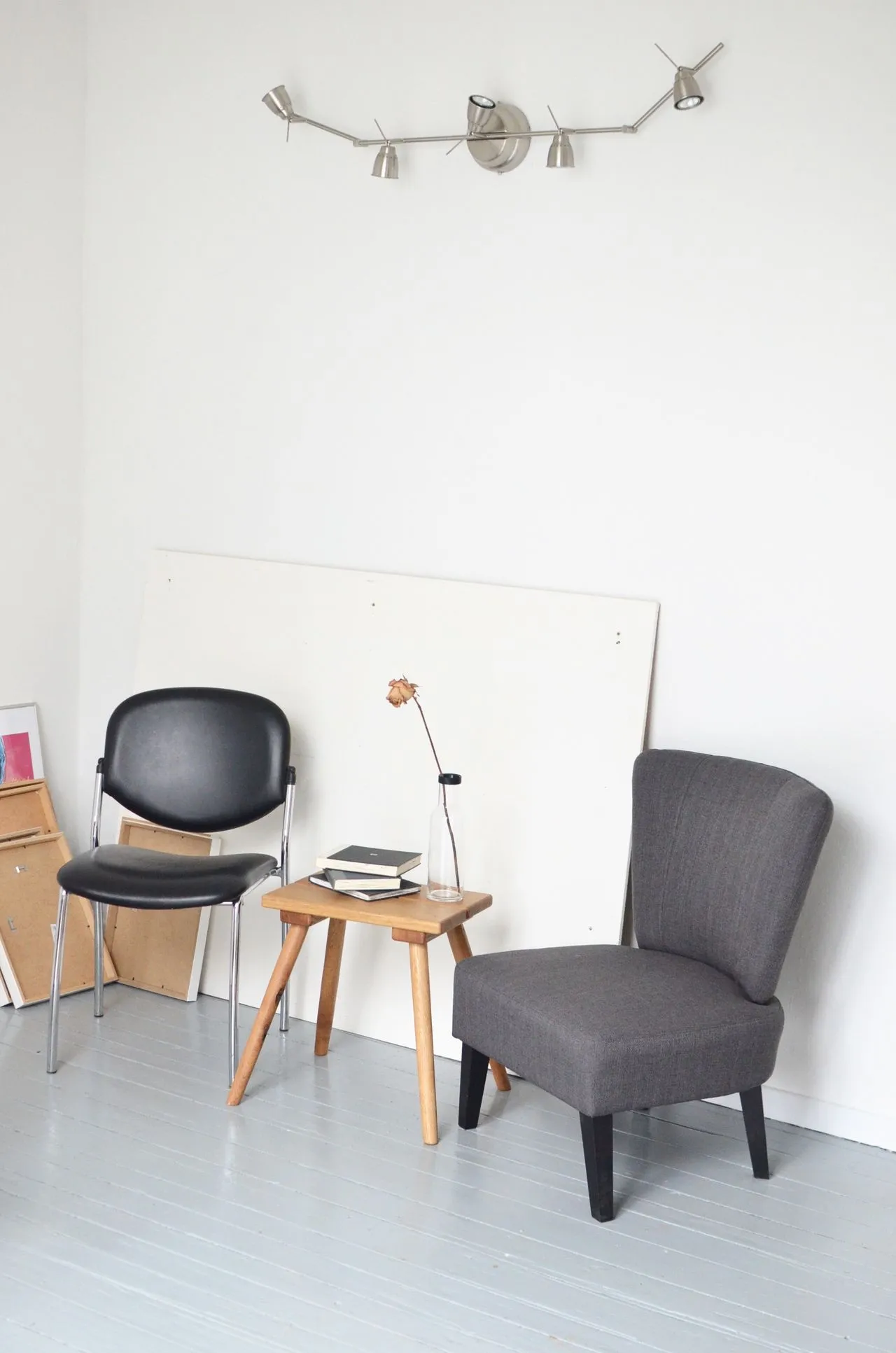 Two chairs and a small table beneath a pale artwork
