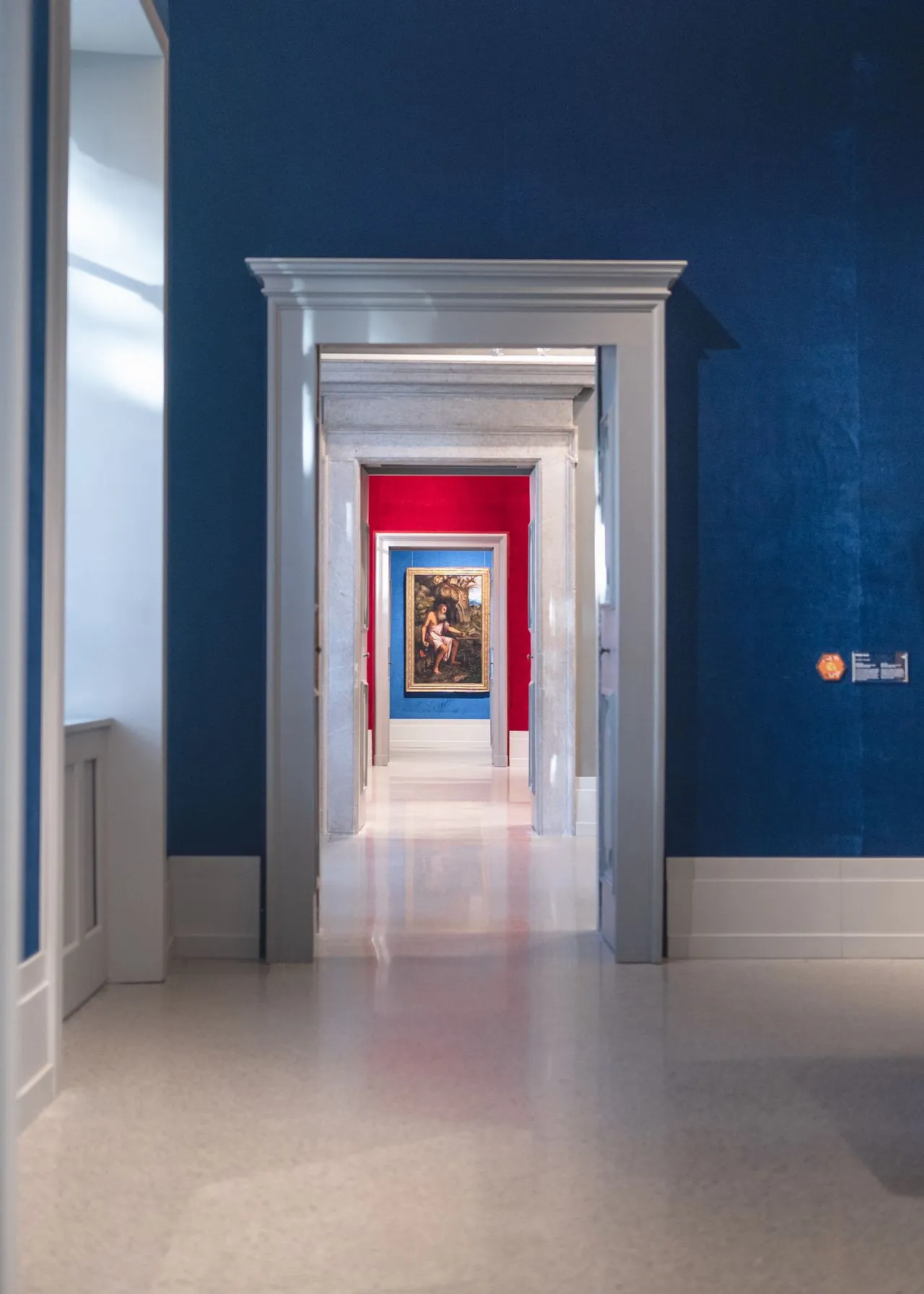 Series of artworks aligned through blue gallery rooms